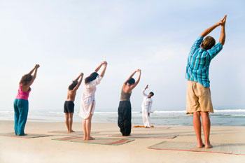 People enjoying a private yoga session on the beach